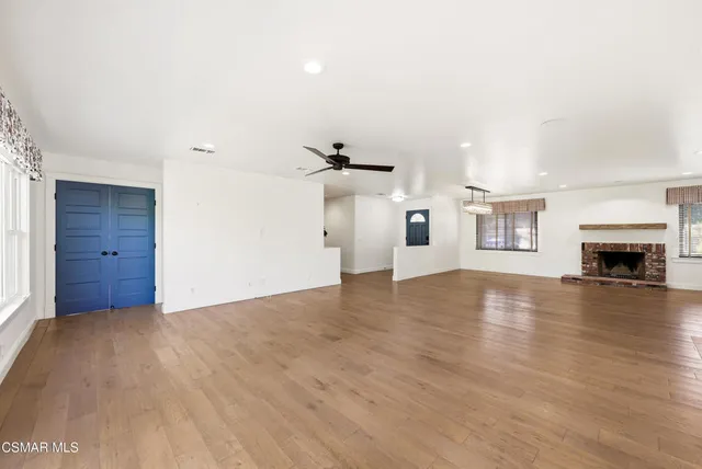 a kitchen with white cabinets and a large window