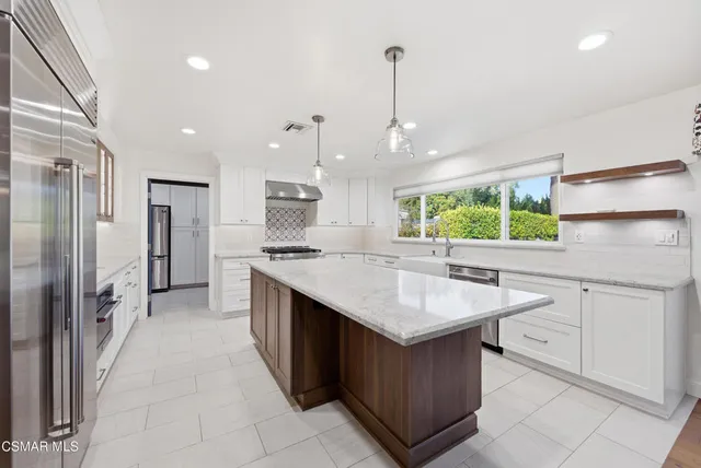 a utility room with stainless steel appliances granite countertop a sink a washer and dryer