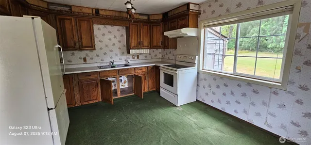 a kitchen with stainless steel appliances granite countertop a sink a stove and a refrigerator