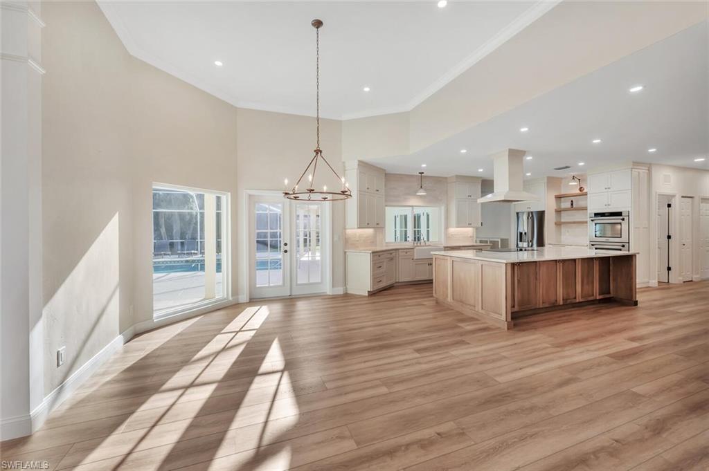 3110 70th Street Southwest Naples, FL 34105 - Photo 12 of 47 a large kitchen with a lot of cabinets and wooden floor