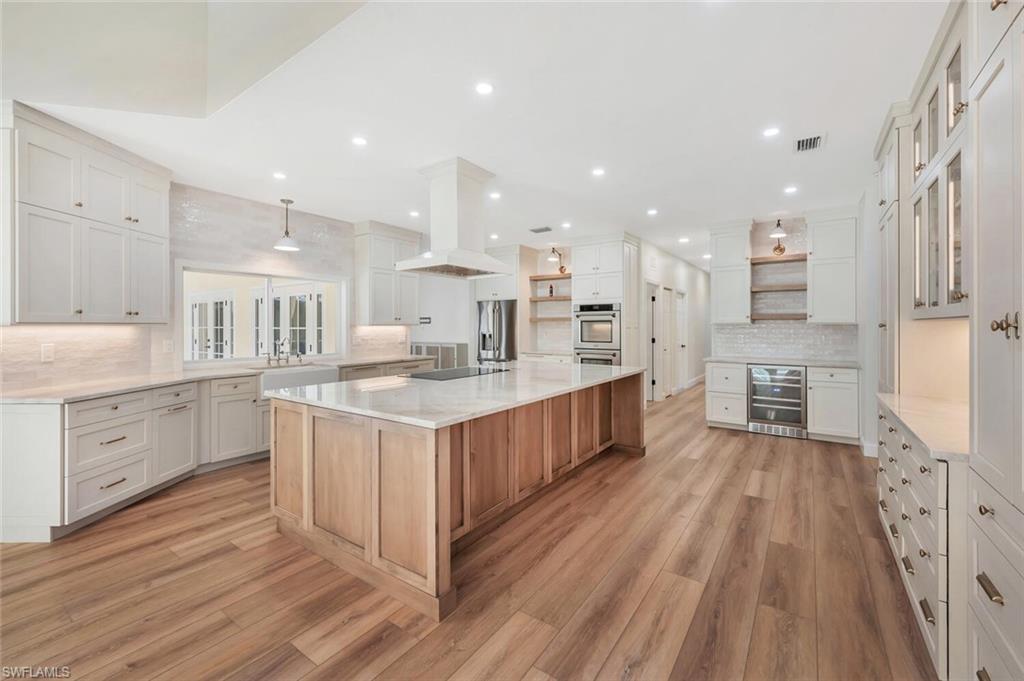 3110 70th Street Southwest Naples, FL 34105 - Photo 13 of 47 a large kitchen with a lot of counter space and wooden floor