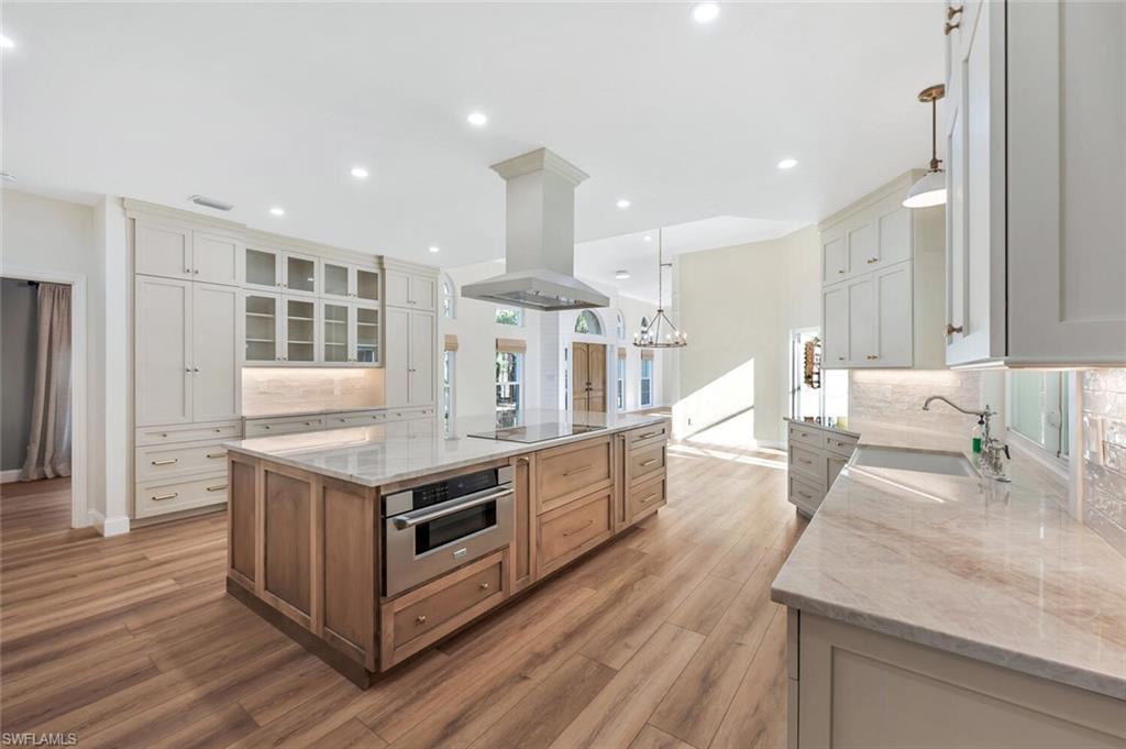 3110 70th Street Southwest Naples, FL 34105 - Photo 14 of 47 a large kitchen with stainless steel appliances granite countertop a lot of counter space and wooden floors