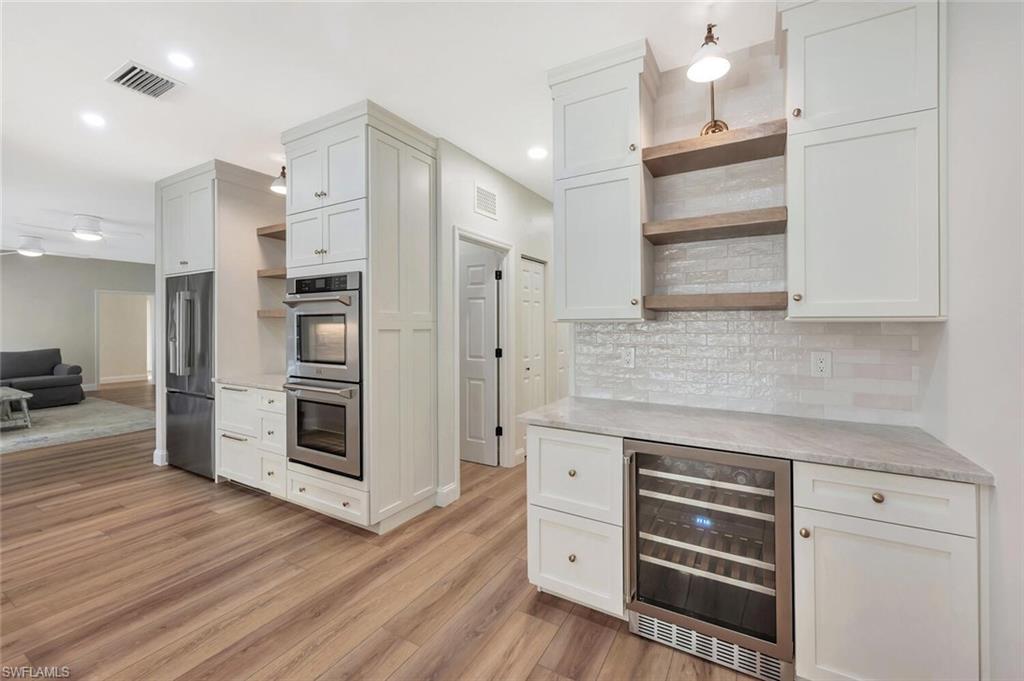 3110 70th Street Southwest Naples, FL 34105 - Photo 16 of 47 a kitchen with stainless steel appliances a refrigerator and cabinets