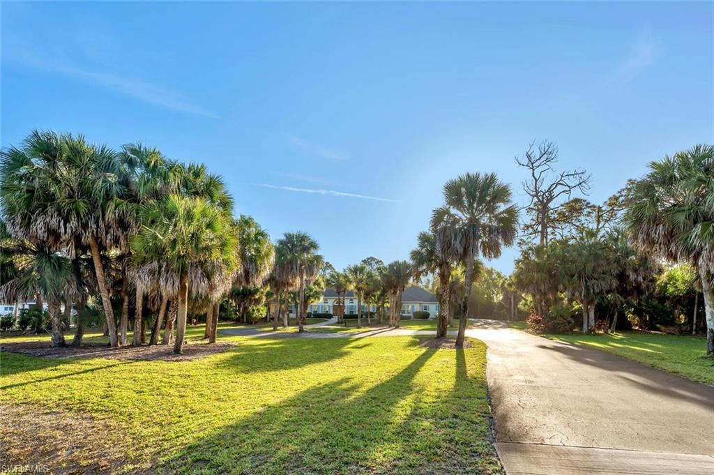 3110 70th Street Southwest Naples, FL 34105 - Photo 2 of 47 a view of swimming pool with outdoor seating and trees