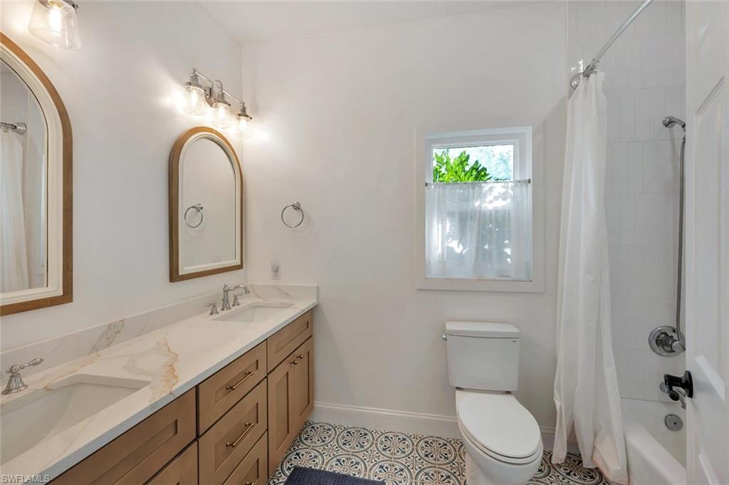 3110 70th Street Southwest Naples, FL 34105 - Photo 30 of 47 a spacious bathroom with a double vanity sink and a mirror