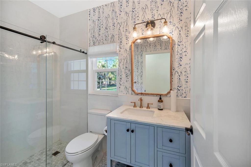 3110 70th Street Southwest Naples, FL 34105 - Photo 34 of 47 a bathroom with a toilet a sink and mirror