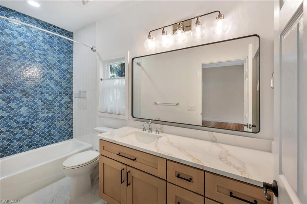 3110 70th Street Southwest Naples, FL 34105 - Photo 36 of 47 a bathroom with a granite countertop sink a toilet and shower