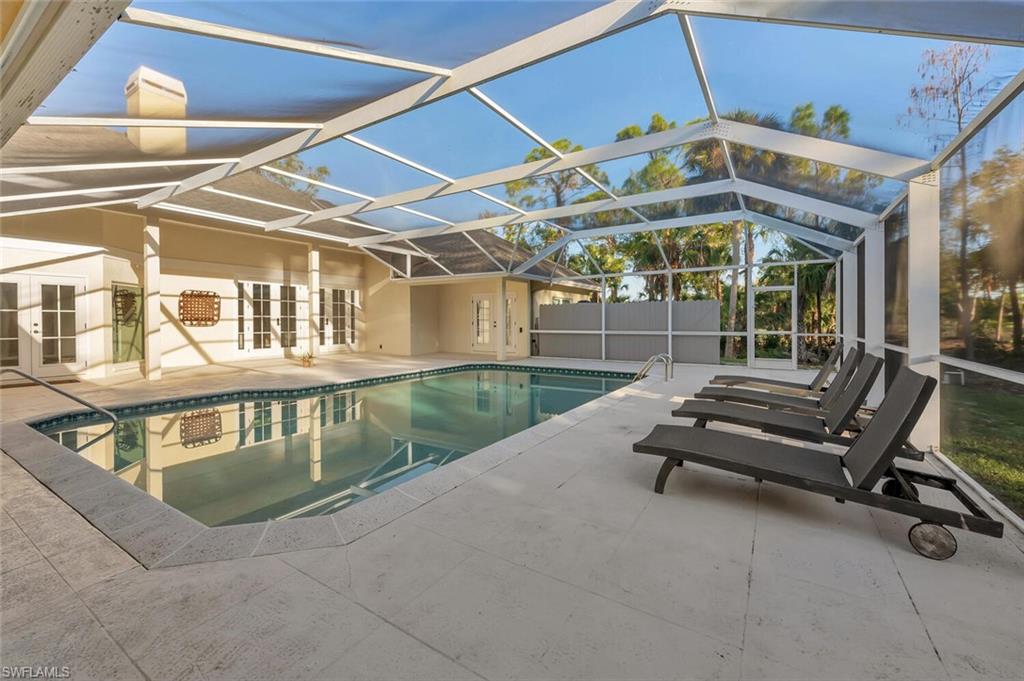 3110 70th Street Southwest Naples, FL 34105 - Photo 42 of 47 a view of a patio with a table and chairs under an umbrella