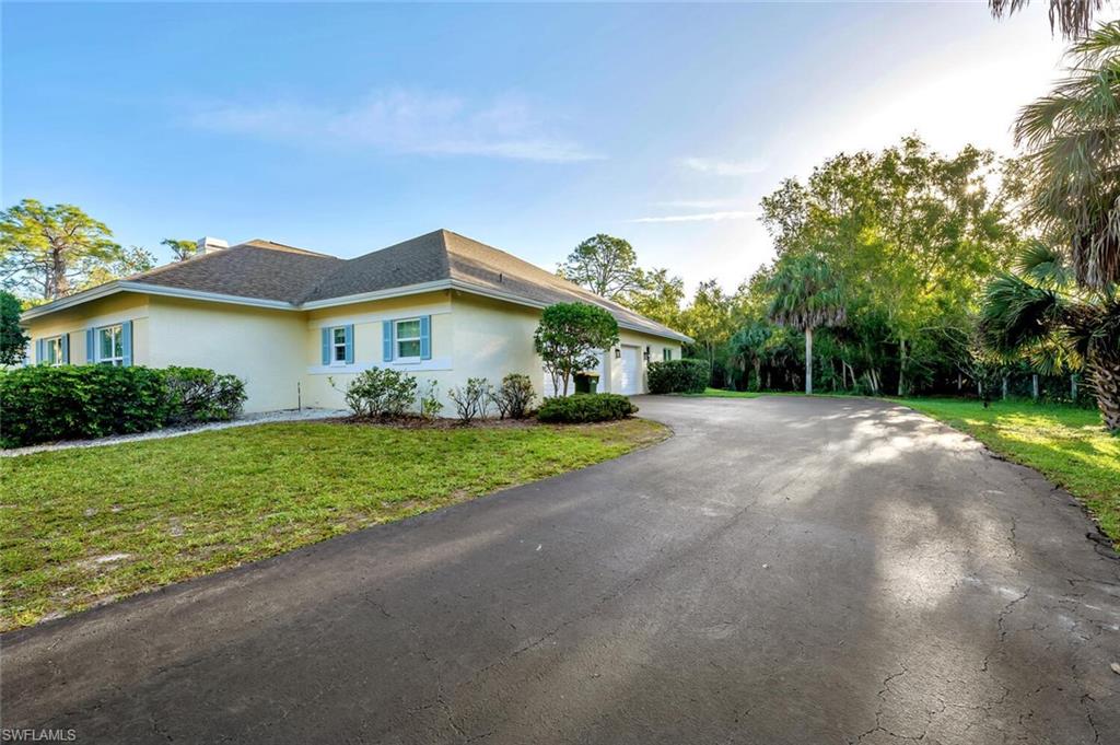 3110 70th Street Southwest Naples, FL 34105 - Photo 43 of 47 a front view of a house with garden