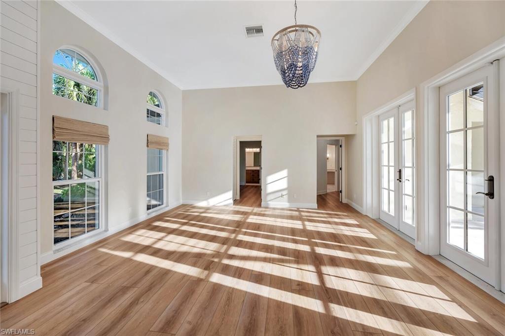 3110 70th Street Southwest Naples, FL 34105 - Photo 8 of 47 a bedroom with a bed and a chandelier