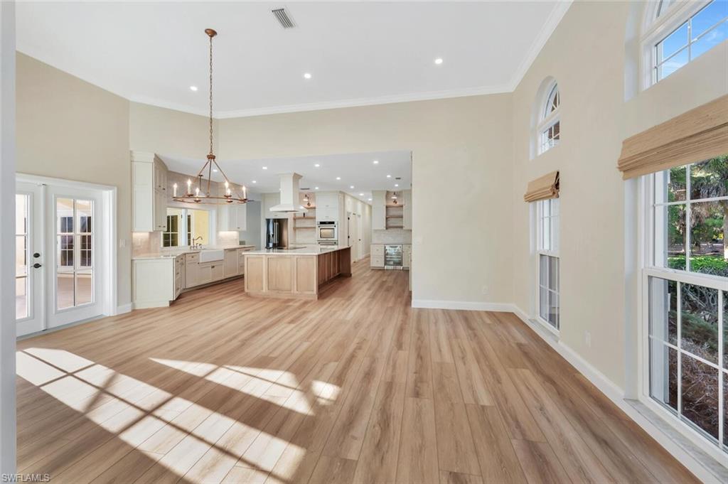 3110 70th Street Southwest Naples, FL 34105 - Photo 10 of 47 a large room with kitchen view and a wooden floor