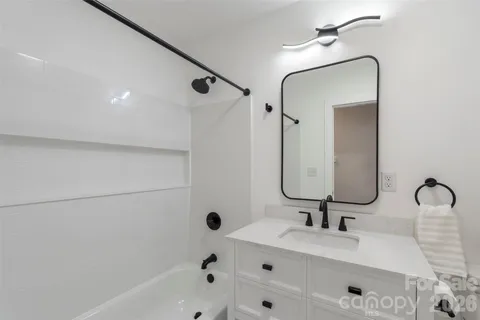 a bathroom with a tub sink and mirror