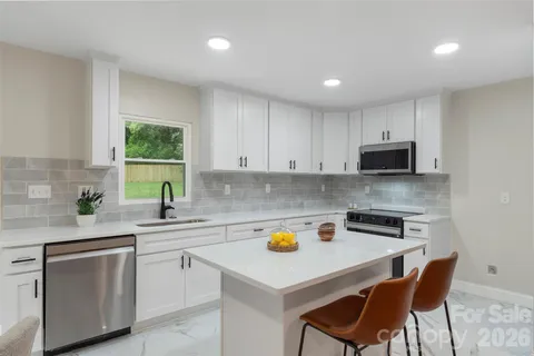 a kitchen with a sink a stove a microwave a counter space and cabinets