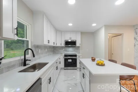 a kitchen with a sink a stove top oven and refrigerator