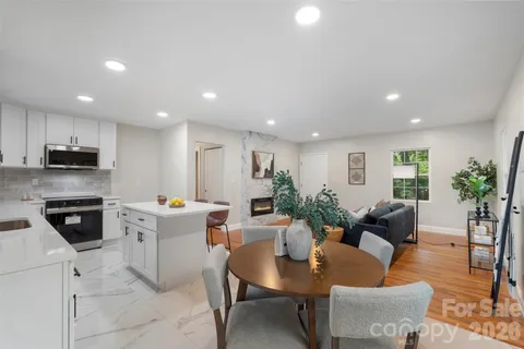 a living room with furniture kitchen view and a potted plant