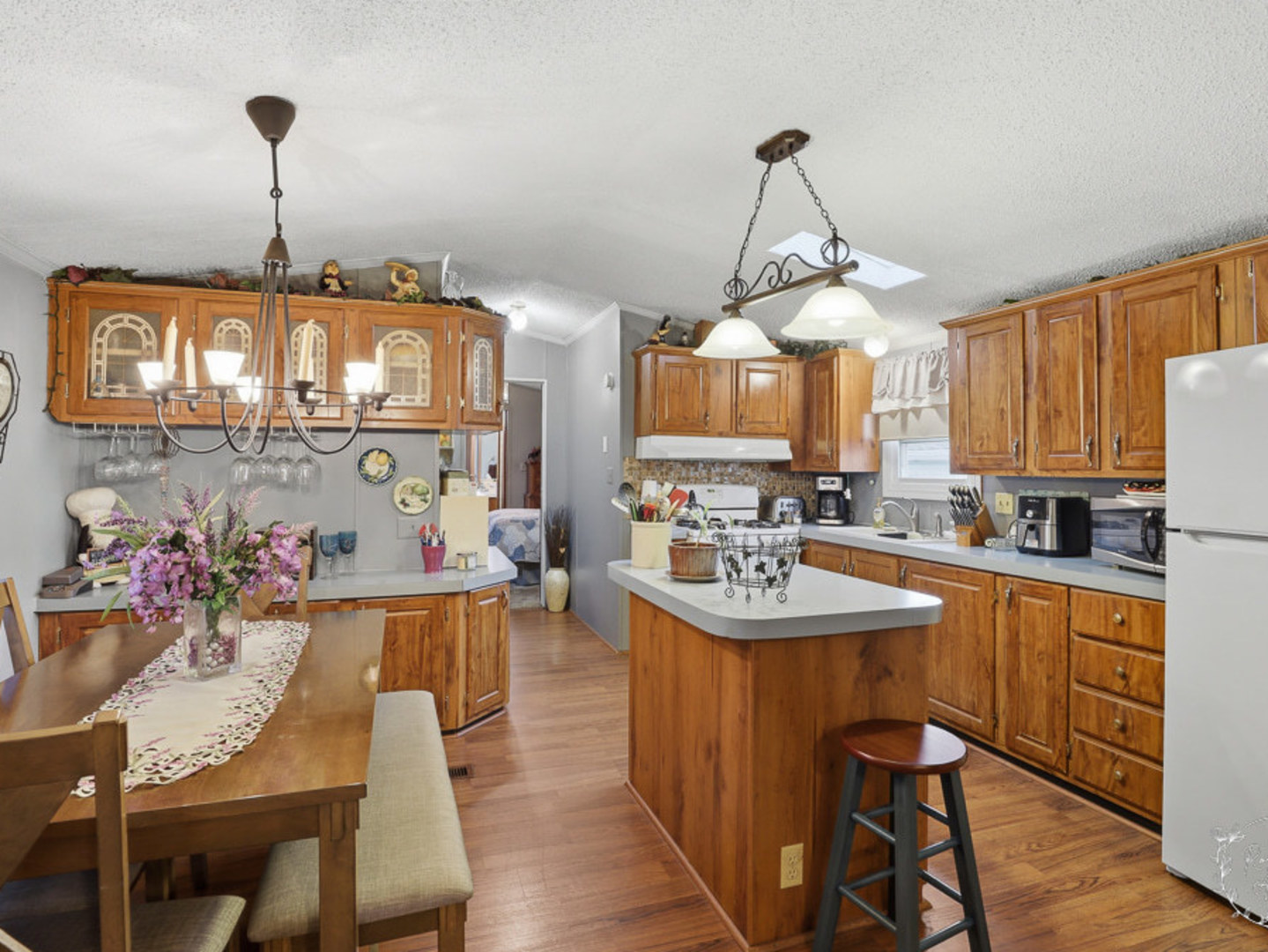 52 Partridge Lane Beecher, IL 60401 - Photo 7 of 24 a kitchen with stainless steel appliances a sink dishwasher a stove a dining table and chairs with wooden floor