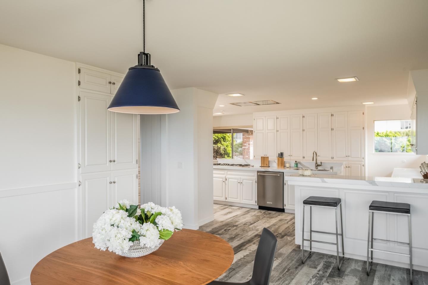 2715 Ribera Road Carmel, CA 93923 - Photo 20 of 41 a kitchen with stainless steel appliances a dining table chairs and white cabinets