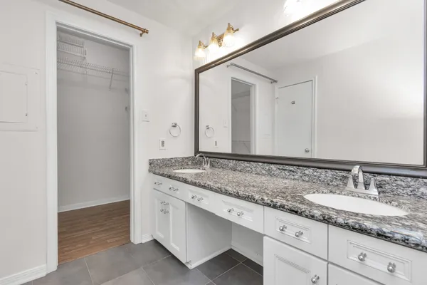 a bathroom with a granite countertop sink and a mirror