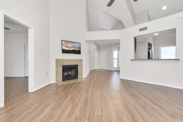 a view of a livingroom with wooden floor and a fireplace
