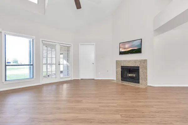a view of empty room with wooden floor and fireplace