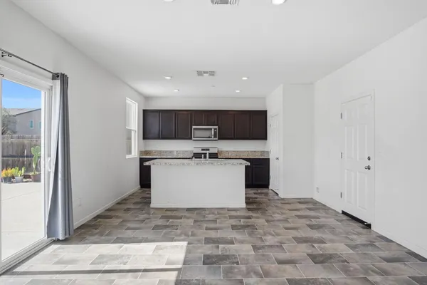 a view of a kitchen with a sink microwave and cabinets