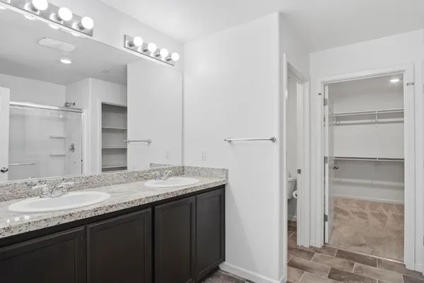 a bathroom with a granite countertop sink shower and a mirror