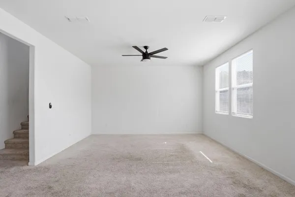 an empty room with a window and a ceiling fan