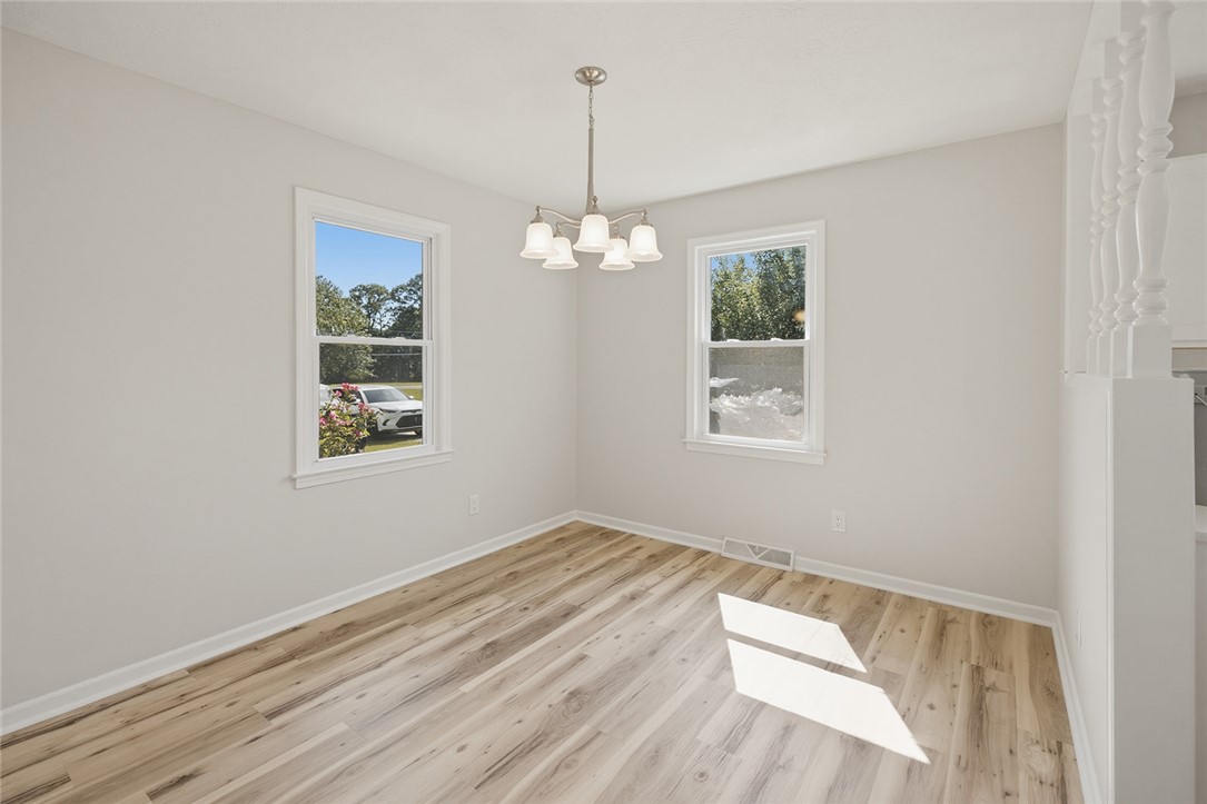 902 Cherokee Road Pelzer, SC 29669 - Photo 13 of 38 Natural light illuminates this versatile room featuring durable wood flooring and a classic chandelier.