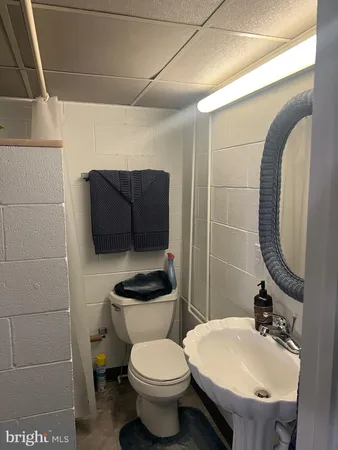 a bathroom with a toilet sink and mirror