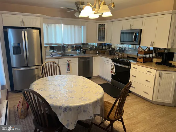 a kitchen with a table chairs refrigerator and microwave