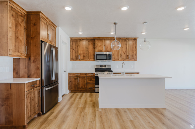 433 North 600 West Smithfield, UT 84335 - Photo 12 of 40 Kitchen featuring wood-finish cabinetry, stainless steel appliances, a center island with sink, subway tile backsplash, and recessed lighting