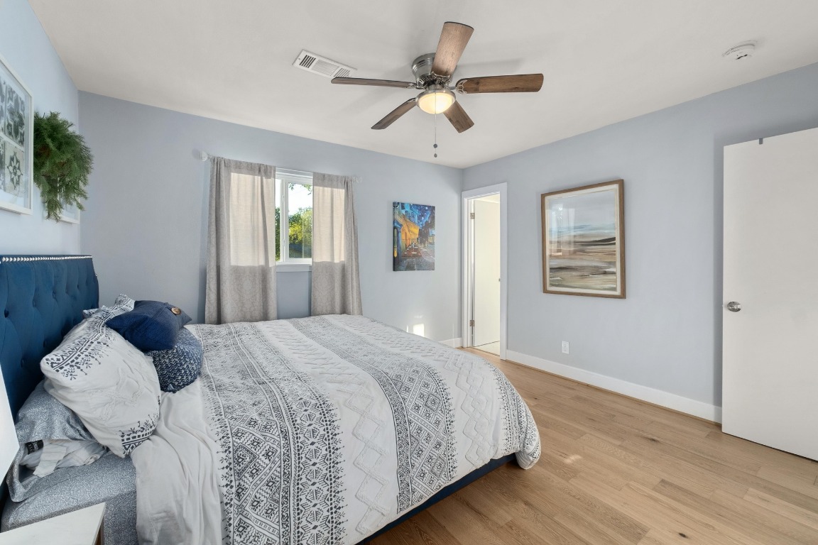 5307 Halmark Drive Austin, TX 78723 - Photo 15 of 31 a bedroom with a large bed chandelier and a window