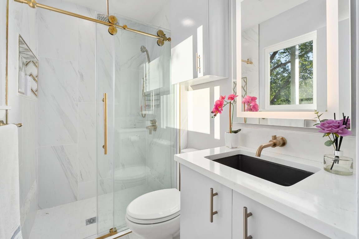 5307 Halmark Drive Austin, TX 78723 - Photo 17 of 31 a bathroom with a sink toilet vanity and shower