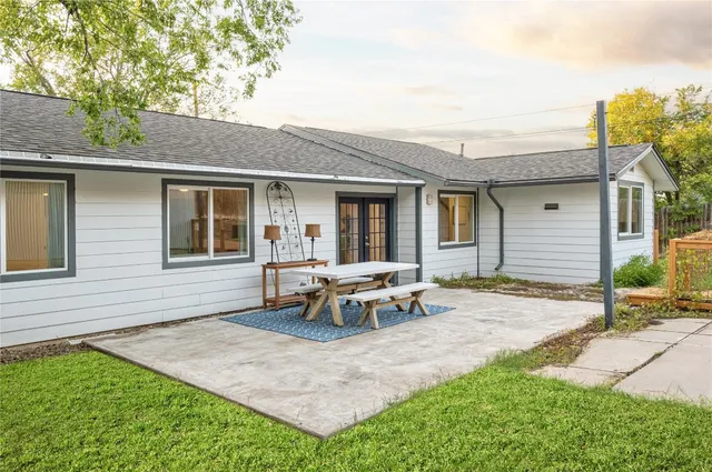 a view of a house with backyard and sitting area