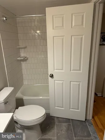 a white toilet and tub sitting next to a bathroom sink