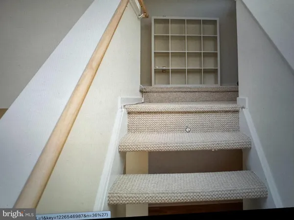 a view of staircase with white walls and a window