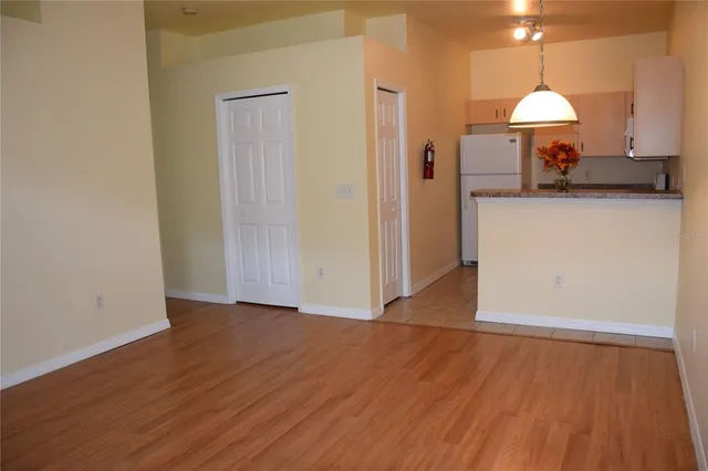 an entryway with wooden floor and chandelier