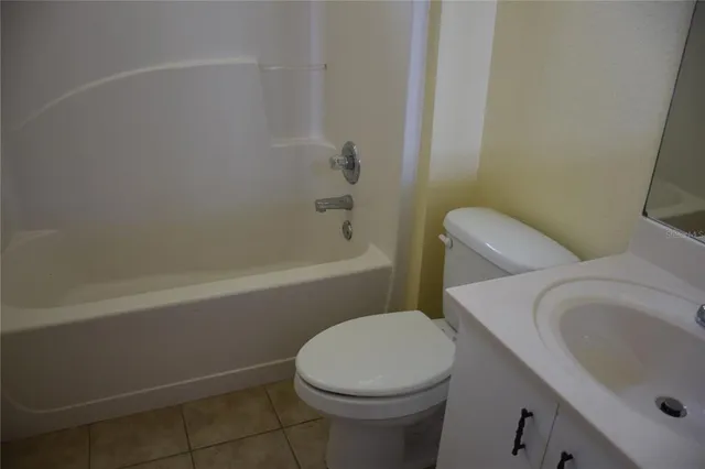 a white toilet sitting next to a bath tub
