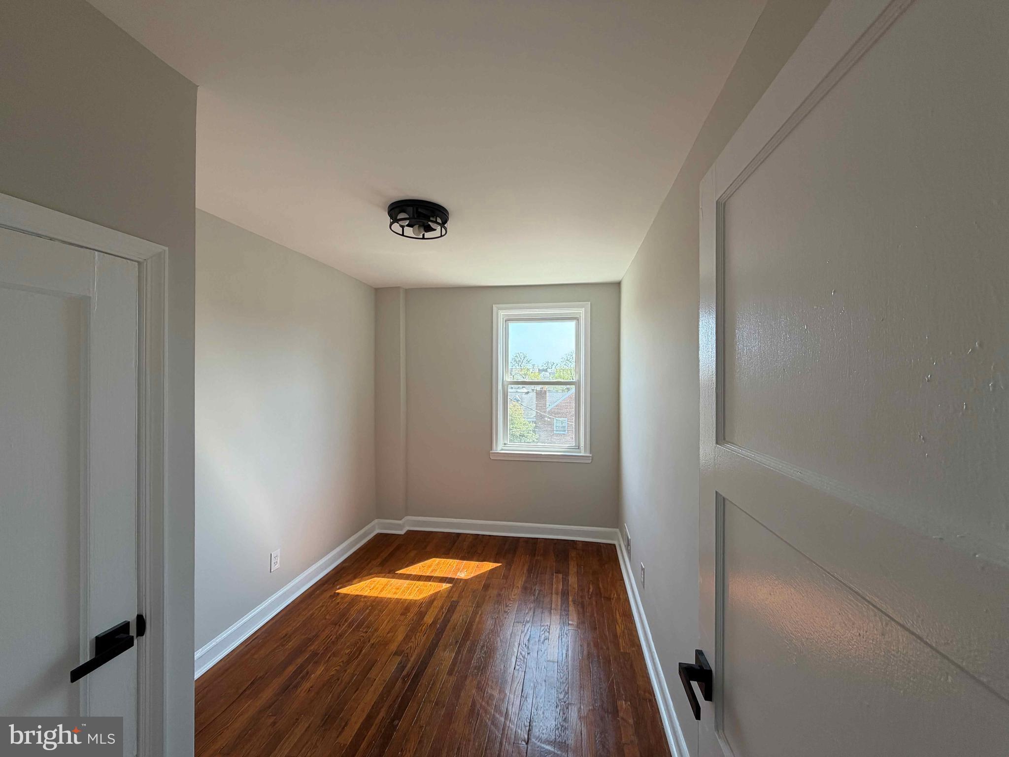 1535 East Cold Spring Lane Baltimore, MD 21218 - Photo 11 of 24 an empty room with wooden floor and windows