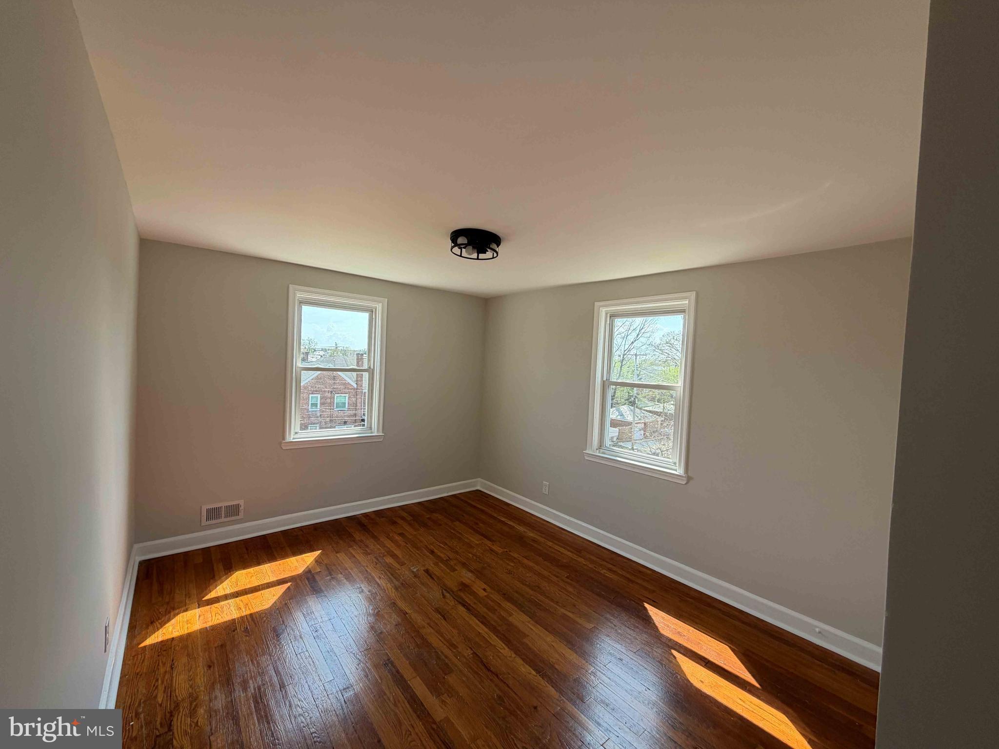 1535 East Cold Spring Lane Baltimore, MD 21218 - Photo 13 of 24 a view of empty room with window and wooden floor
