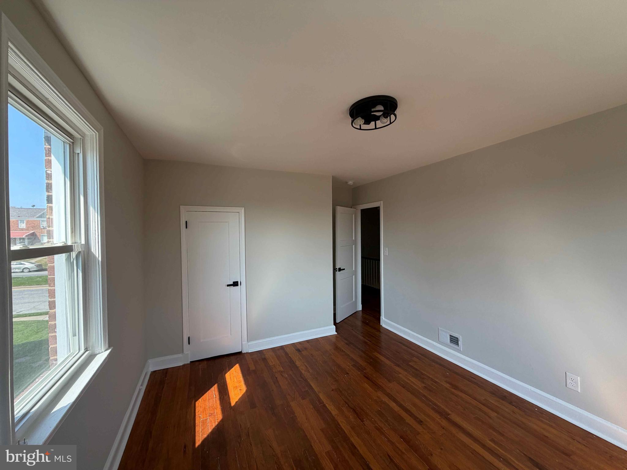 1535 East Cold Spring Lane Baltimore, MD 21218 - Photo 14 of 24 an empty room with wooden floor and windows
