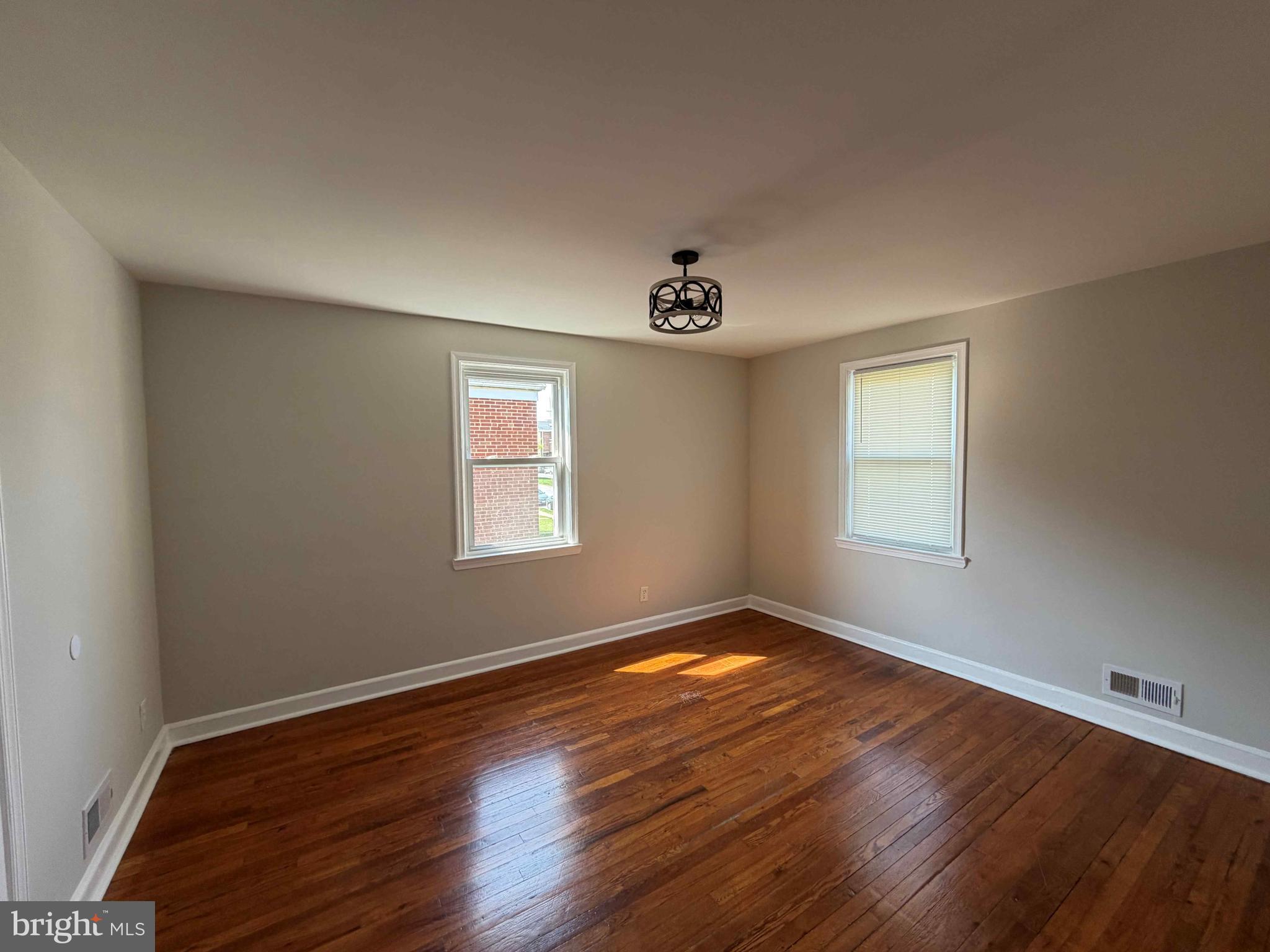 1535 East Cold Spring Lane Baltimore, MD 21218 - Photo 15 of 24 a view of an empty room with wooden floor and a window