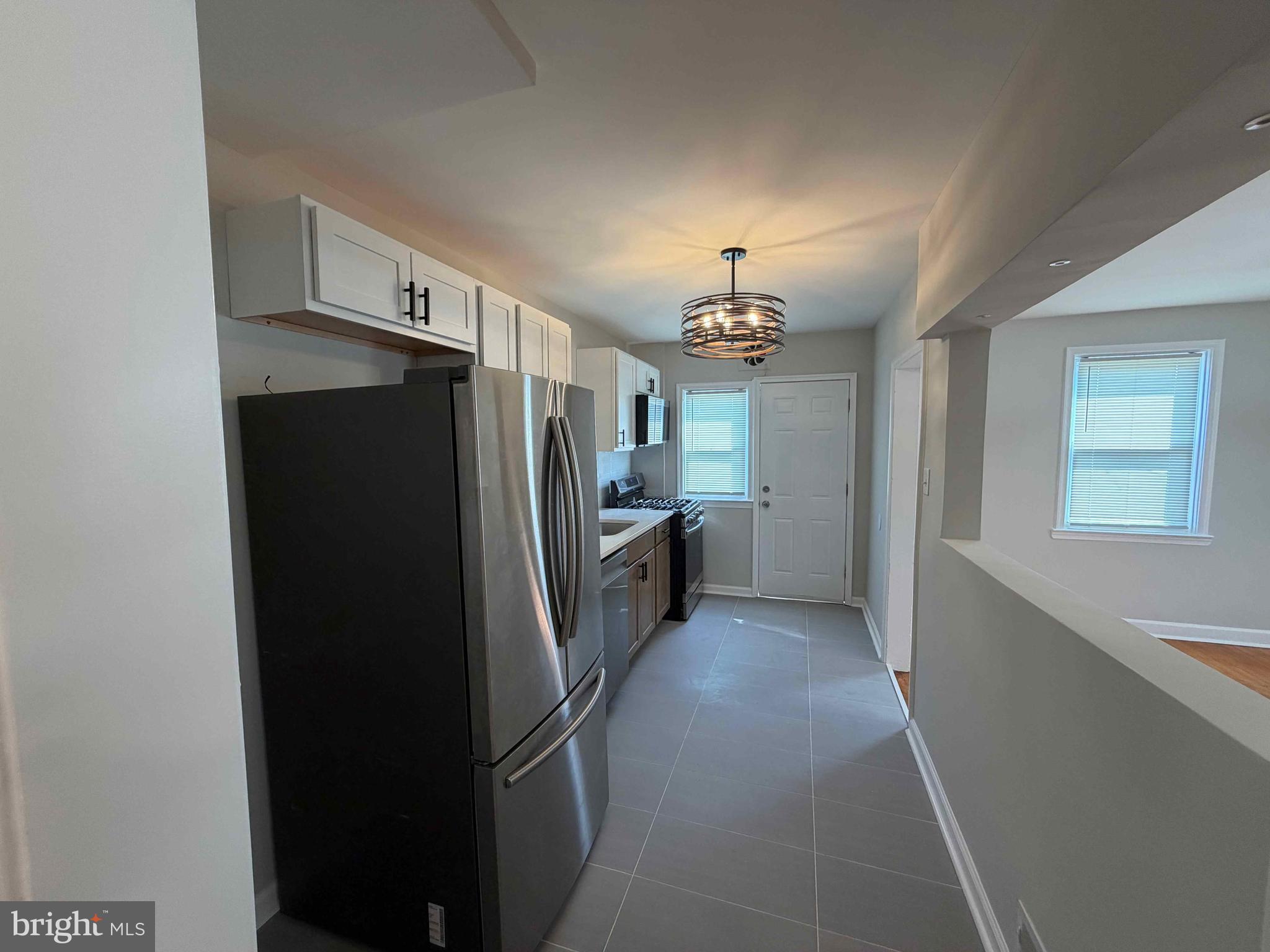 1535 East Cold Spring Lane Baltimore, MD 21218 - Photo 9 of 24 a view of a kitchen with a refrigerator a sink and dishwasher cabinets