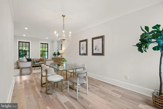 a kitchen with stainless steel appliances granite countertop a stove a refrigerator a kitchen island a dining table and chairs with wooden floor