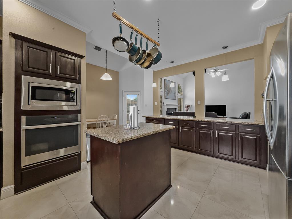 2317 Wellesly Road Rowlett, TX 75089 - Photo 4 of 39 a kitchen with stainless steel appliances granite countertop a stove a sink and a microwave