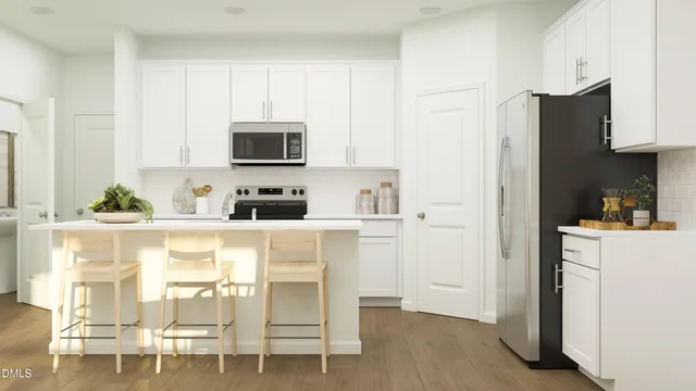 a kitchen with stainless steel appliances white cabinets and wooden floor