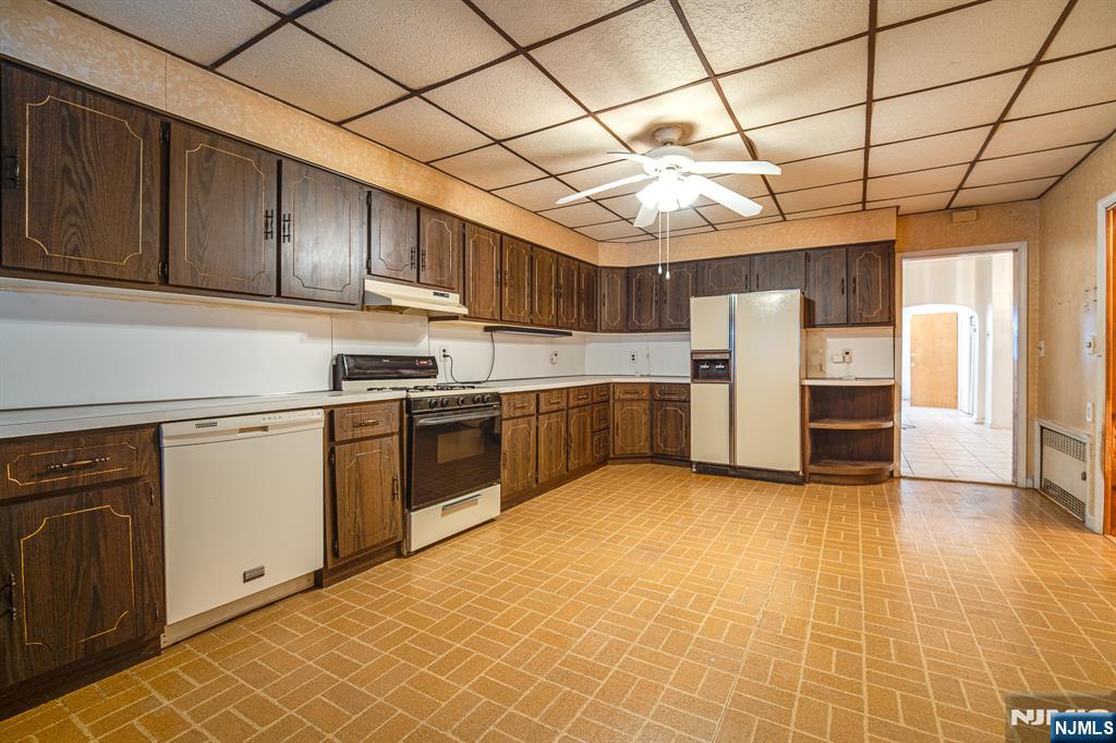 390 Lafayette Street Newark, NJ 07105 - Photo 11 of 40 a kitchen with stainless steel appliances granite countertop a refrigerator and wooden cabinets