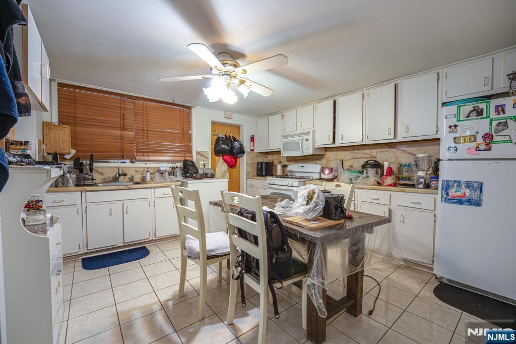 390 Lafayette Street Newark, NJ 07105 - Photo 17 of 40 a kitchen with white cabinets and white appliances