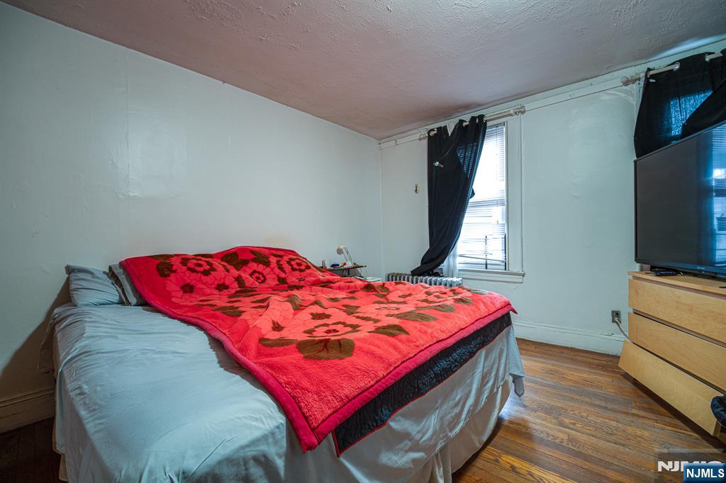 390 Lafayette Street Newark, NJ 07105 - Photo 24 of 40 a bed sitting in a bedroom next to a window