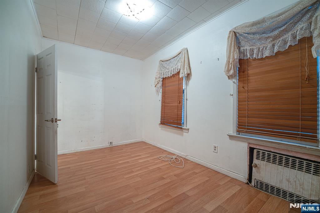 390 Lafayette Street Newark, NJ 07105 - Photo 8 of 40 a view of an empty room with wooden floor and a window
